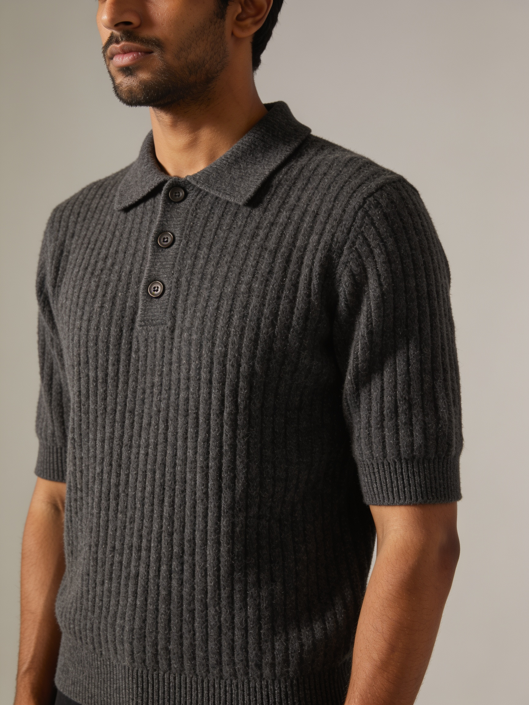 Model wearing The Smoke Room wide-rib knit polo in charcoal with a three-button placket and horn-finish buttons