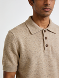 Model wearing The Weather Report donegal knit polo in oatmeal, flecked with rust and slate