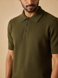 Model wearing The Orchard knit polo in deep moss olive with a ribbed three-button placket