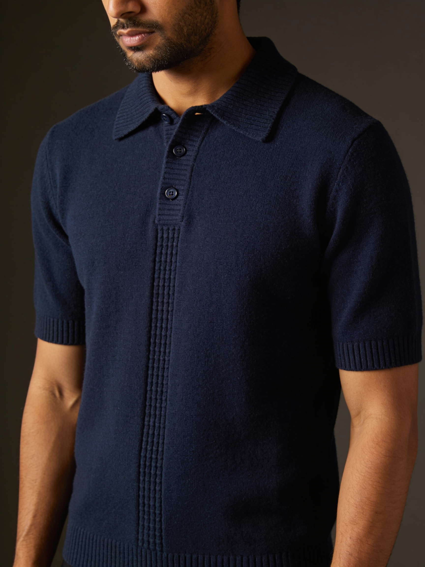 Model wearing The Last Train knit polo in midnight navy with an extended ribbed placket and tonal buttons