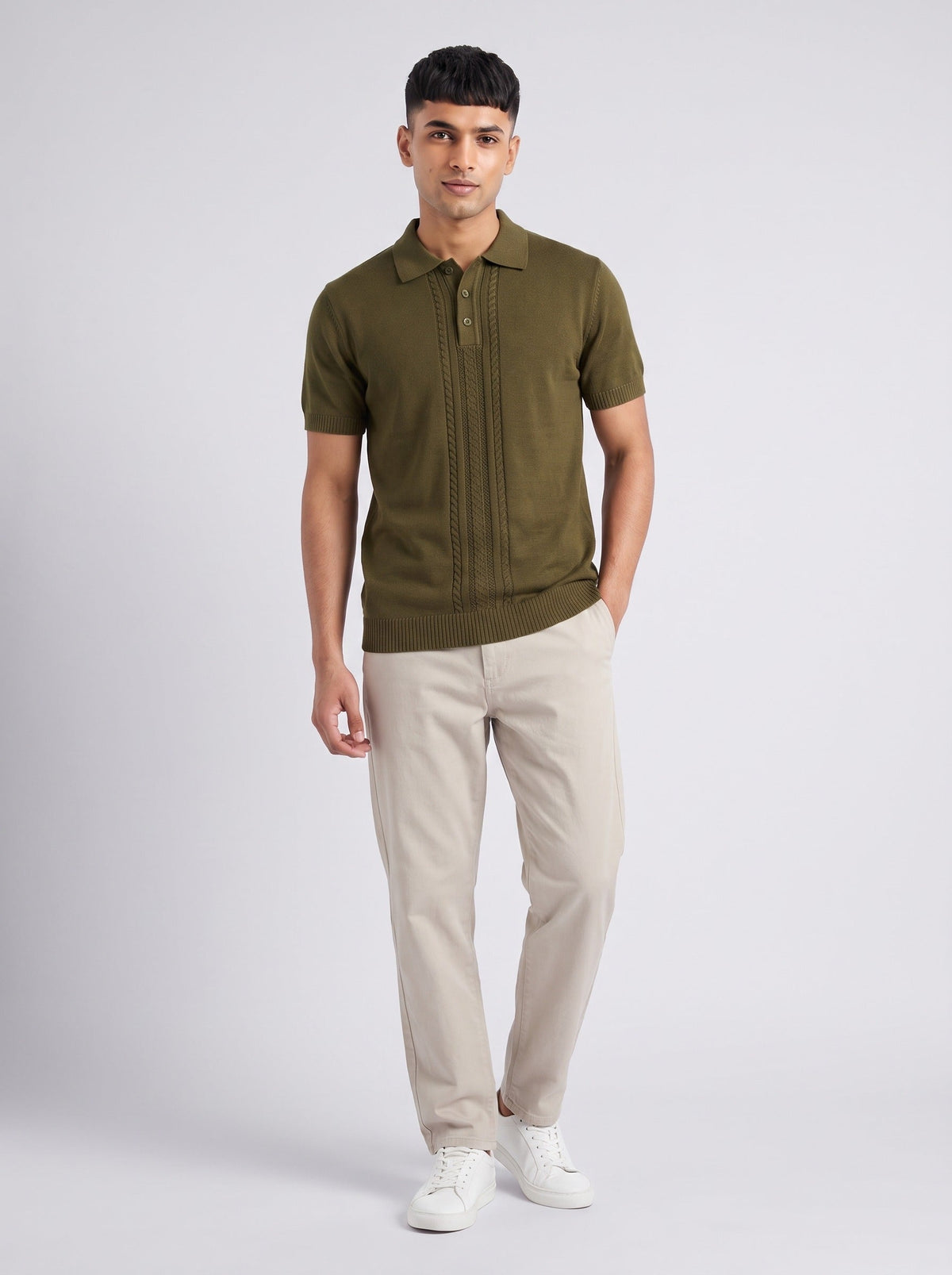 Model wearing The Orchard olive knit polo with a full-length centre cable panel, with stone trousers